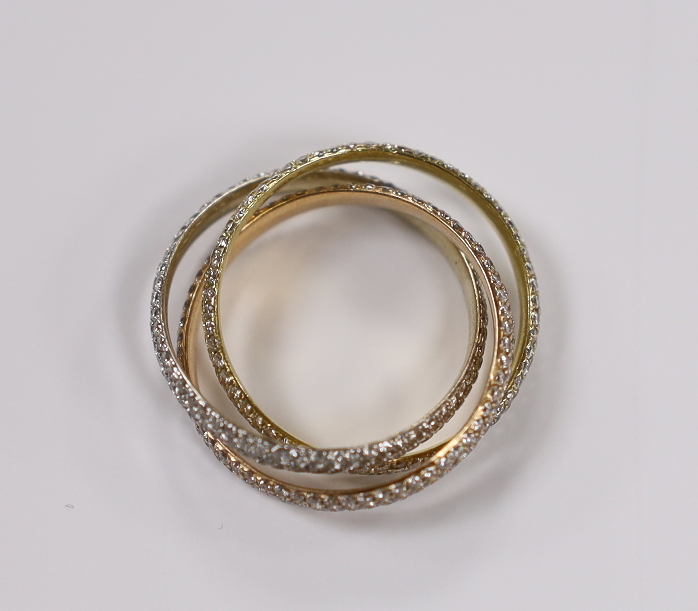 A three colour yellow metal and pave set diamond triple band 'Russian' wedding ring, size Q, gross weight 4.6 grams.